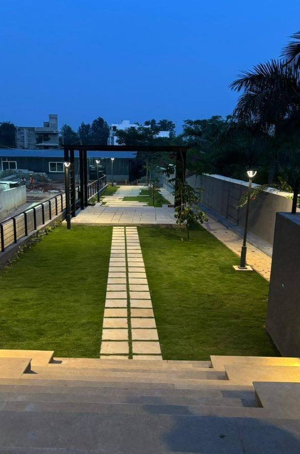 Landscaped lawn walkway with pergola lighting at dusk